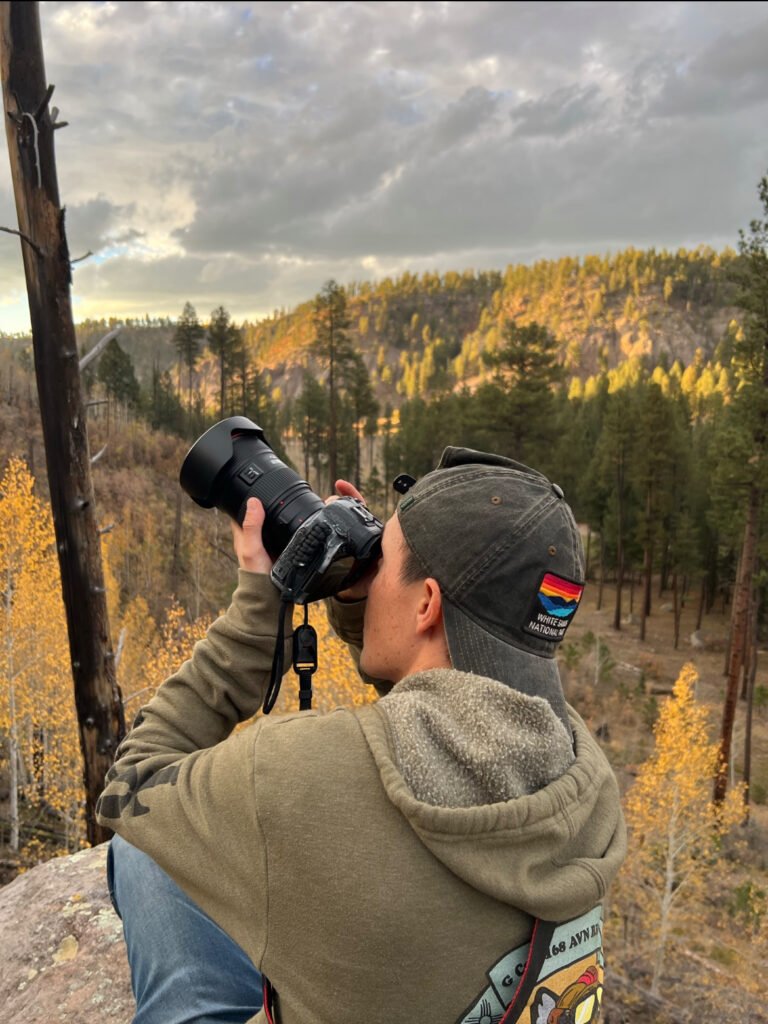 Camping In the Rain: A Definitive Guide (Based on my experience!) 4 A man taking a picture with his camera on a rock.