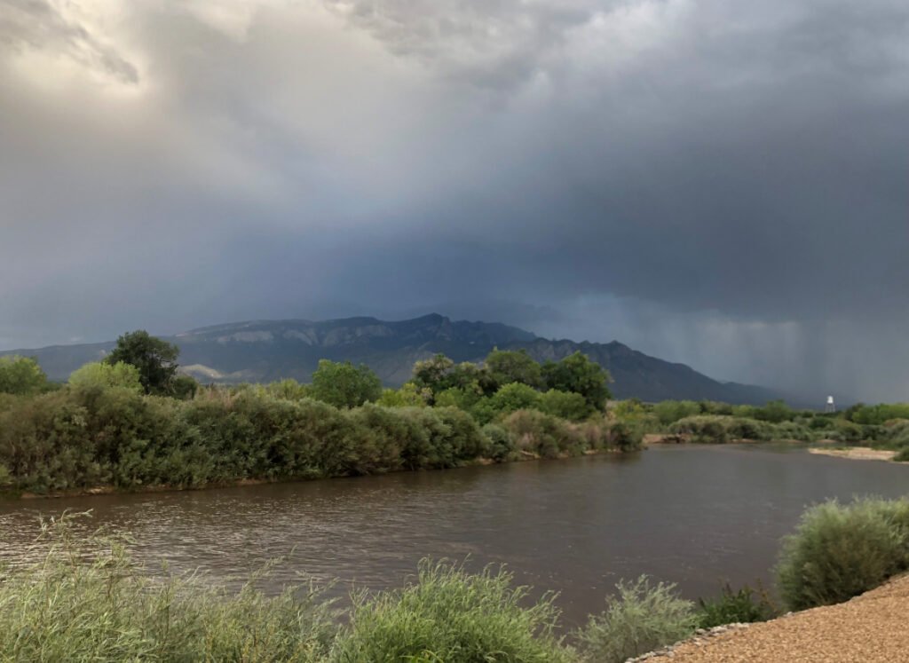 13 Things That Can Go Wrong While Camping… and How to Deal with Them 3 A stormy sky over a river with mountains in the background.