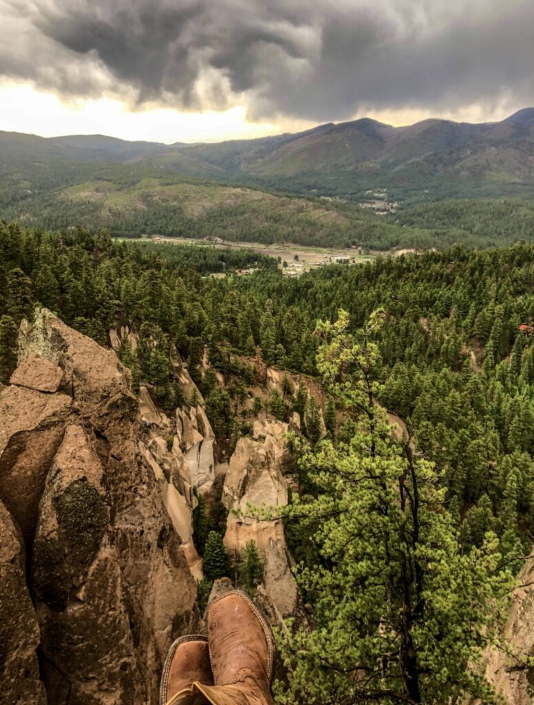 Solo Camping As A Woman: My Safety Tips & Advice When Camping Alone! 3 A person's feet on a cliff overlooking a valley.