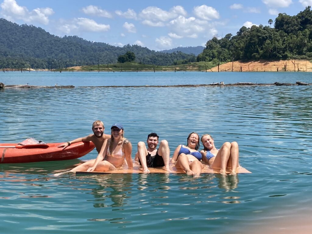 A group of people sitting on a raft in Thailand.