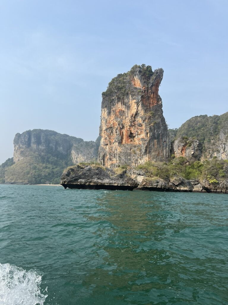 The breathtaking view of a rock formation in the water, perfect for budget travelers exploring Thailand.